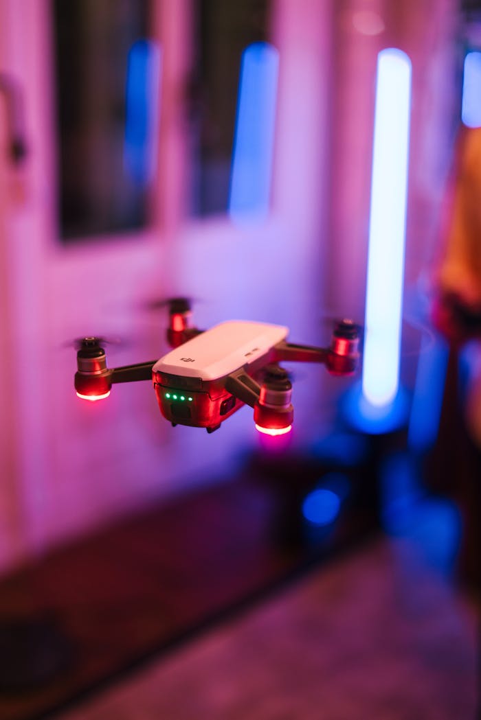 A vibrant flying drone with LED lights captured in an indoor setting, showcasing advanced technology.